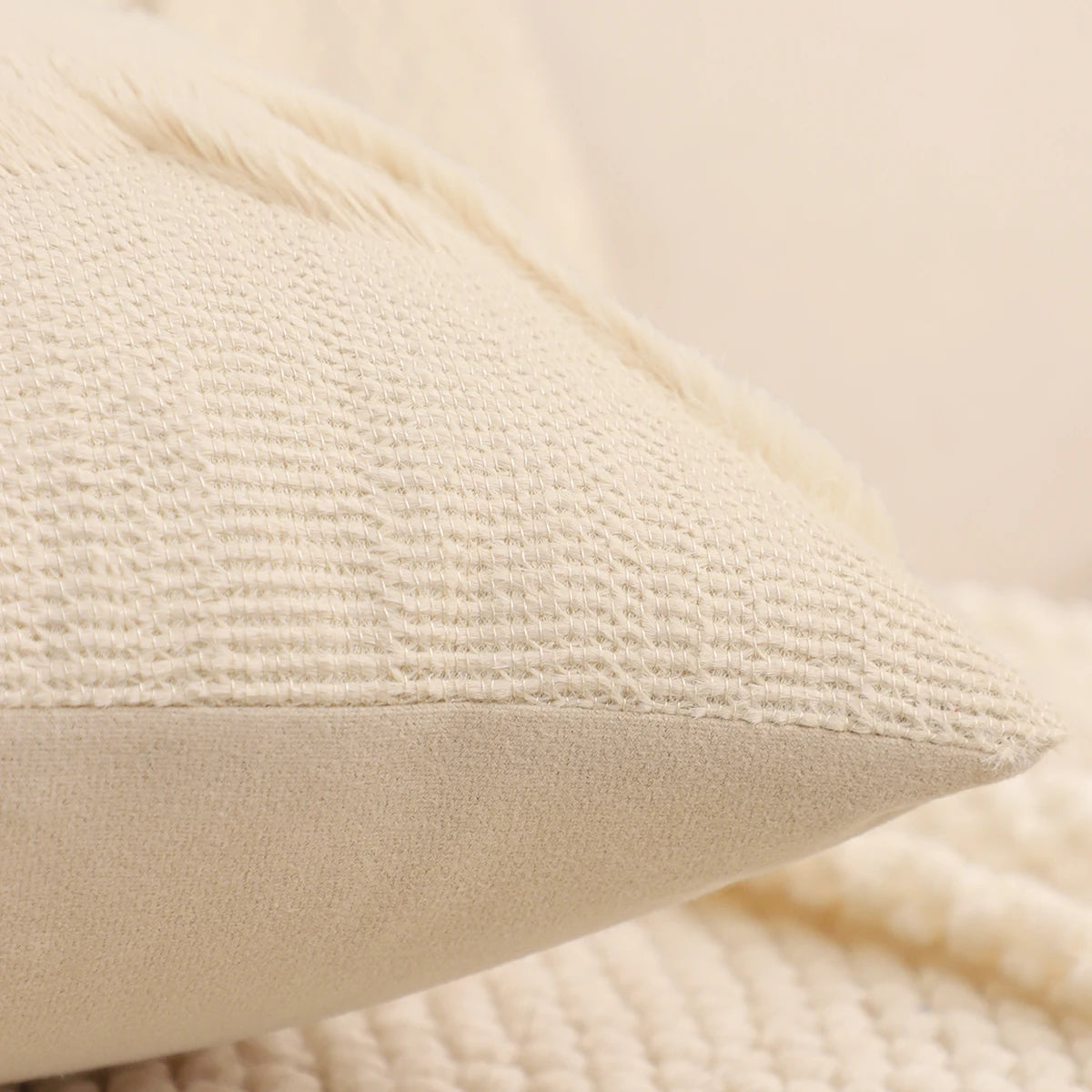 Vue de côté d'une housse de coussin de Noël Ivoire au tissu tricoté à fines côtes