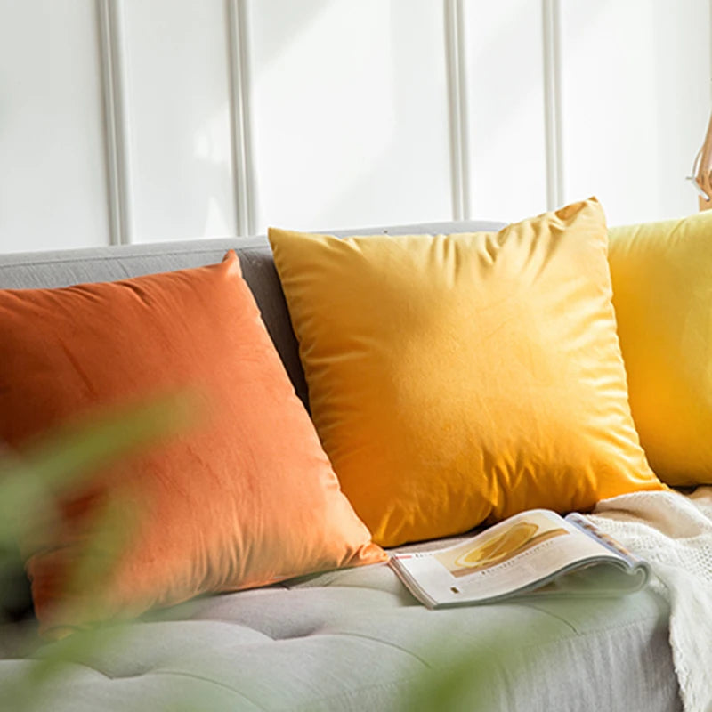 Housse de coussin en velours lisse Jaune Intense sur un canapé gris