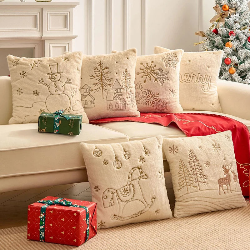 Six housses de coussin de Noël Écru à motifs tissés en fil Doré sur un canapé avec un plaid Rouge