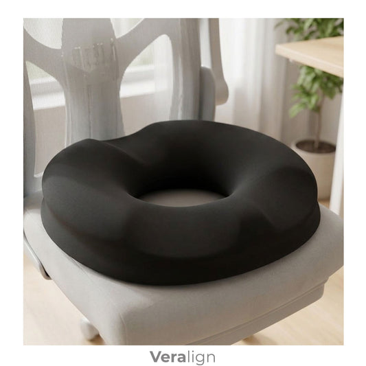 Coussin d’assise ergonomique évidé Veralign noir posé sur une chaise de bureau dans une ambiance chaleureuse