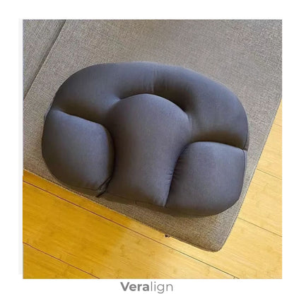 Coussin cervical cocon carbone posé sur un canapé gris clair, usage détente - Veralign