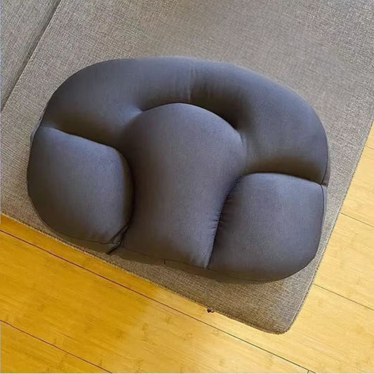 Coussin cervical cocon carbone posé sur un canapé gris clair, usage détente - Veralign