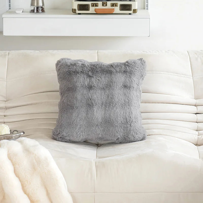 Housse de coussin fausse fourrure Moumoute Gris à relief ondulé sur un canapé clair, 45x45cm