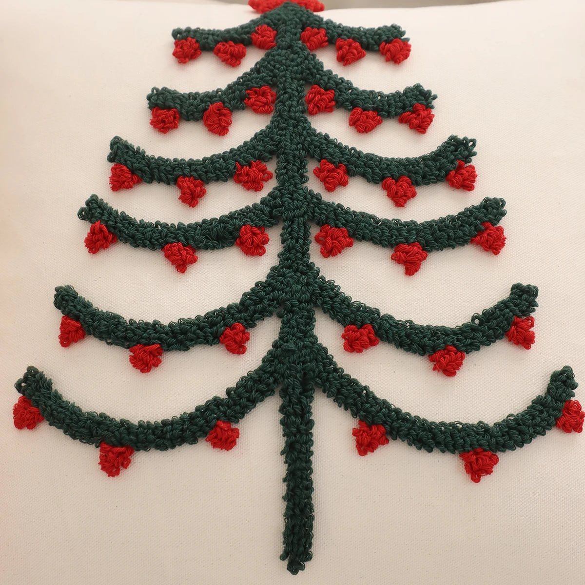 Gros plan sur le sapin Vert décoré de boules Rouges d'une housse de coussin de Noël en bouclette