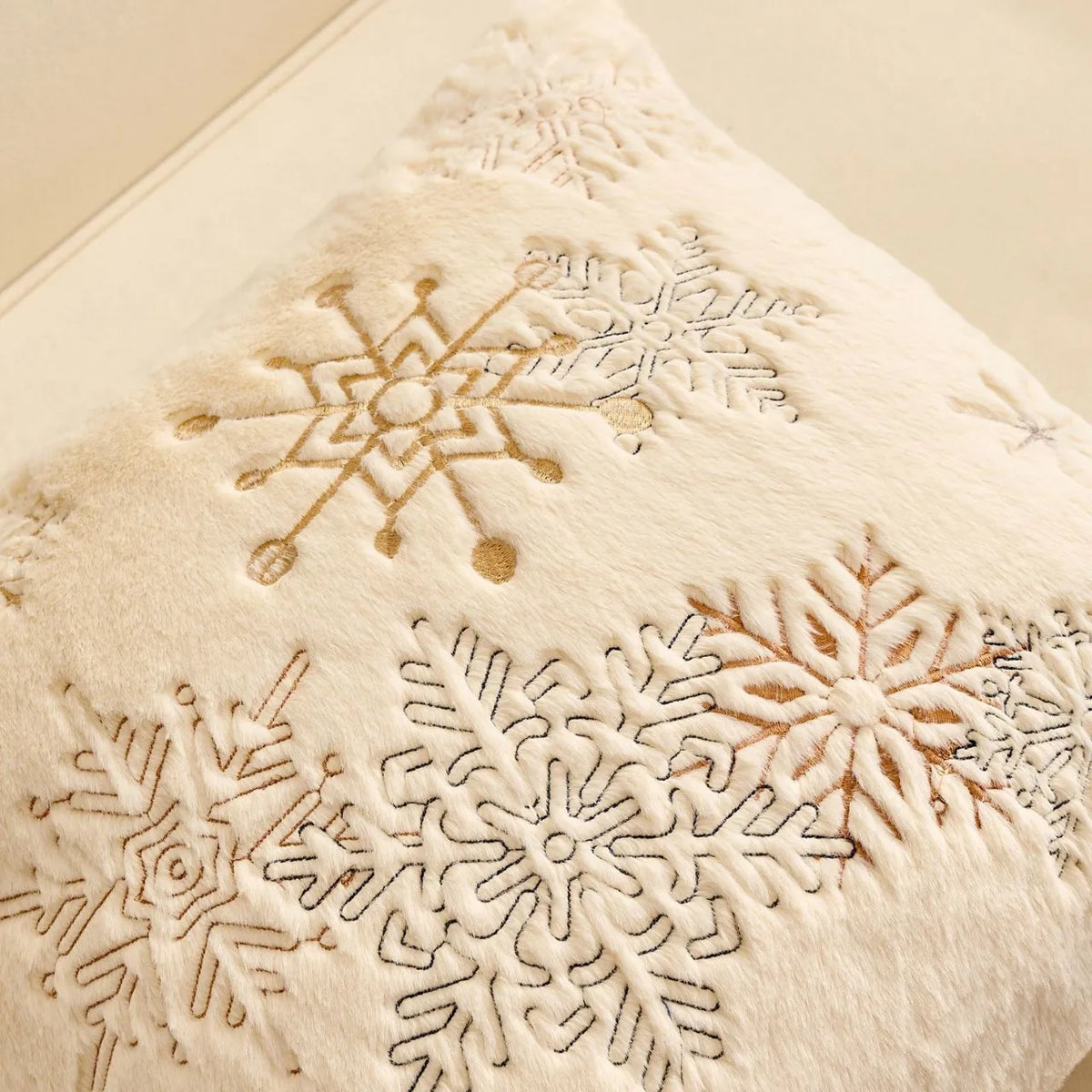 Gros plan sur les flocons tissés en fil Doré d'une housse de coussin de Noël Écru