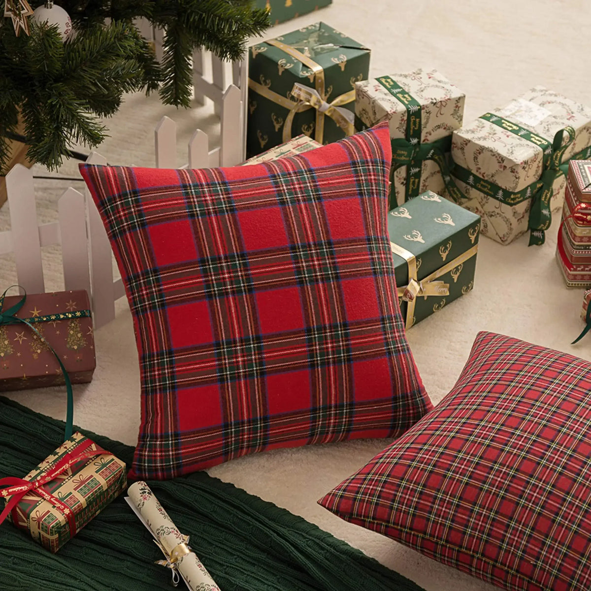 Housse de coussin Tartan Rouge 45x45cm posée près de cadeaux de Noël