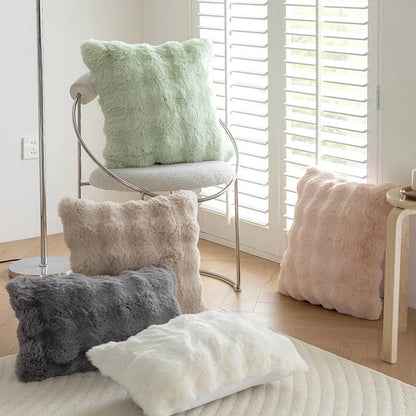 Housses de coussin fausse fourrure Moumoute Vert Menthe, Rose Poudré, Gris et Blanc dans un salon lumineux