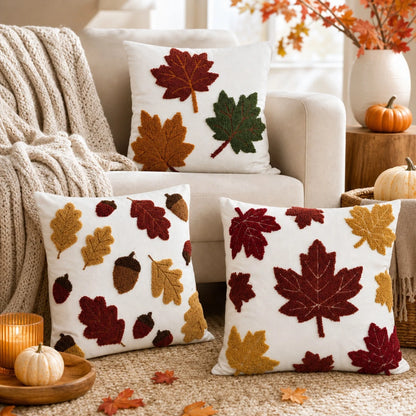 Trois housses de coussin Feuilles d'Érable sur fond Blanc posées sur un canapé en automne